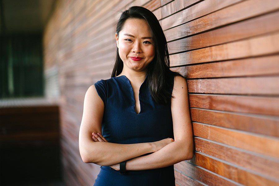 Woman Standing Against Wall with Arms Crossed